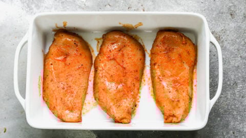 Three raw pieces of meat in a baking dish