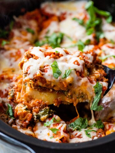 Crockpot lasagna being scooped out of a slow cooker