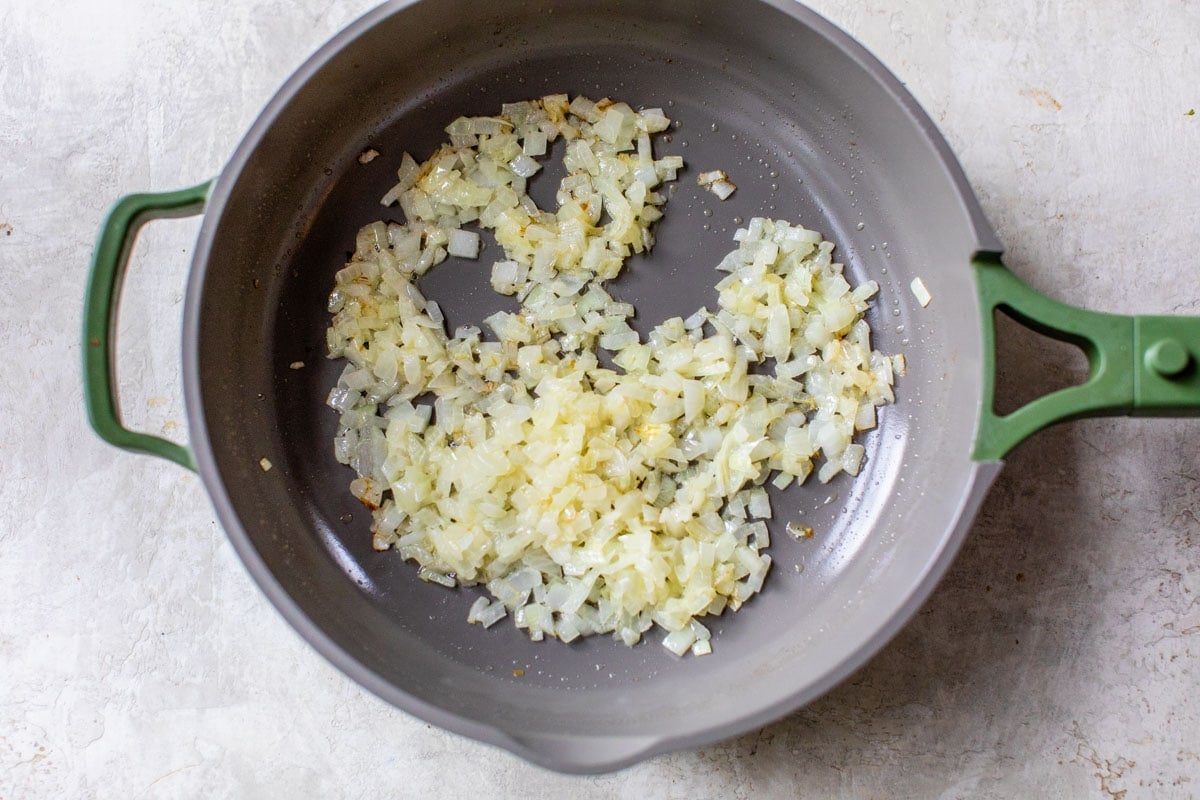 sauted onions in a skillet is the first step to easy crockpot potato soup