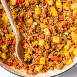 Ground beef and potatoes with red peppers in a pot