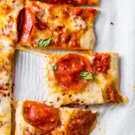 whole wheat crust topped with cheese and pepperoni on parchment paper