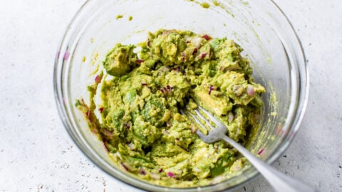 Simple homemade guac being mashed in a bowl
